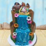 A two tiered Moana Cake with a buttercream waterfall and Moana Cake toppers.