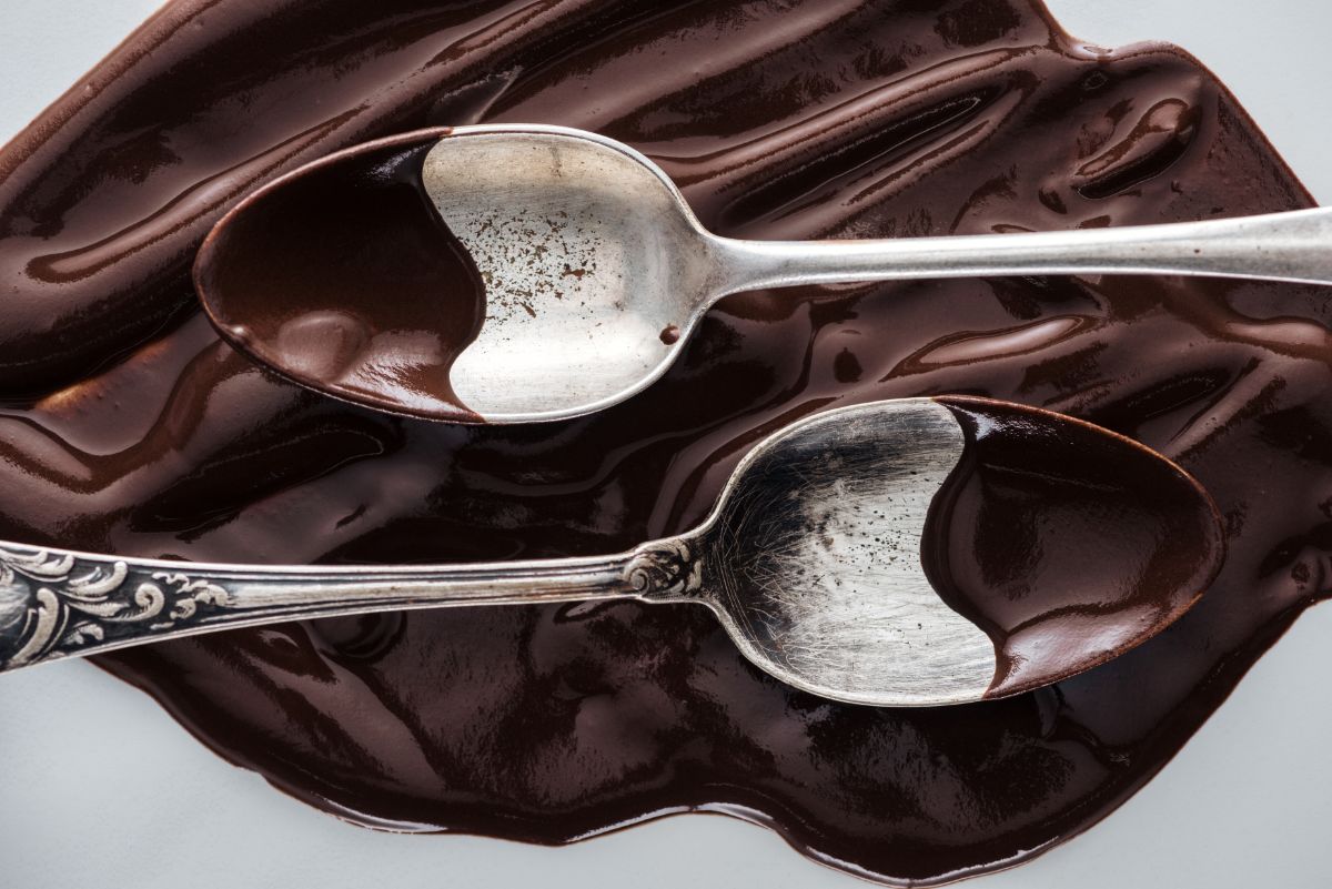 Two spoons showing tempered and untempered chocolate.