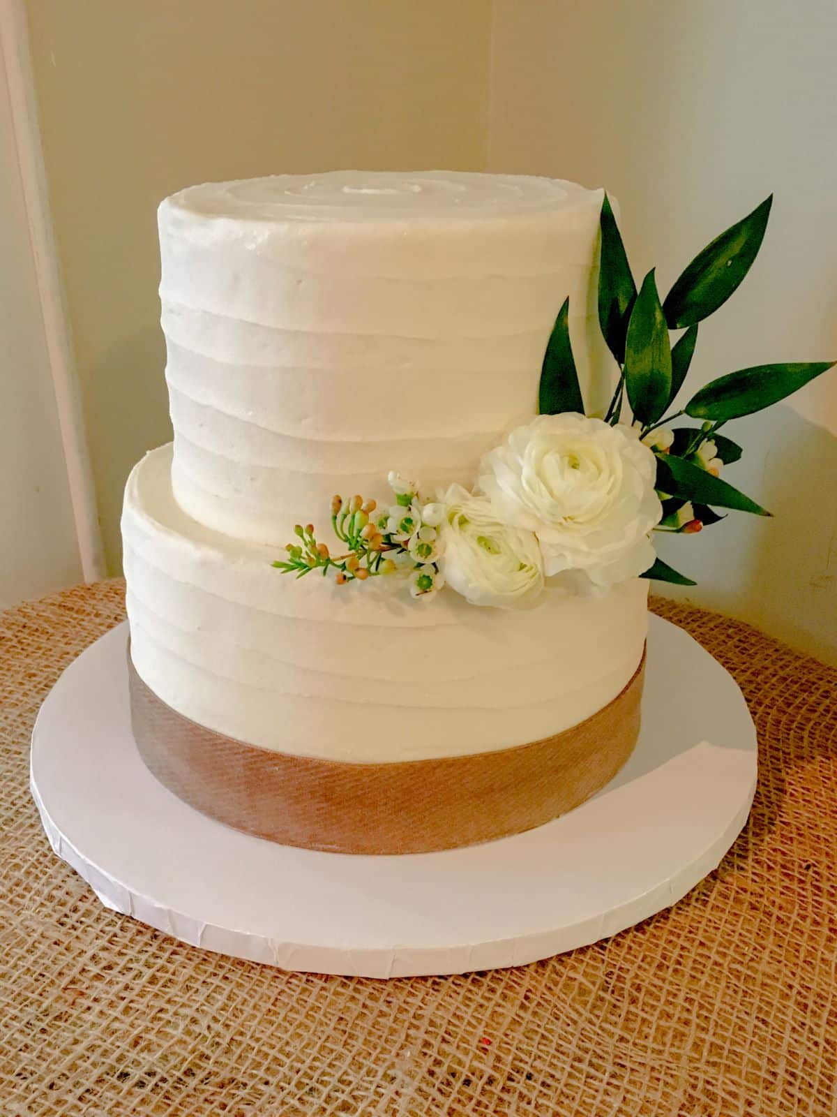 A simple minimalist wedding cake with fresh flowers.