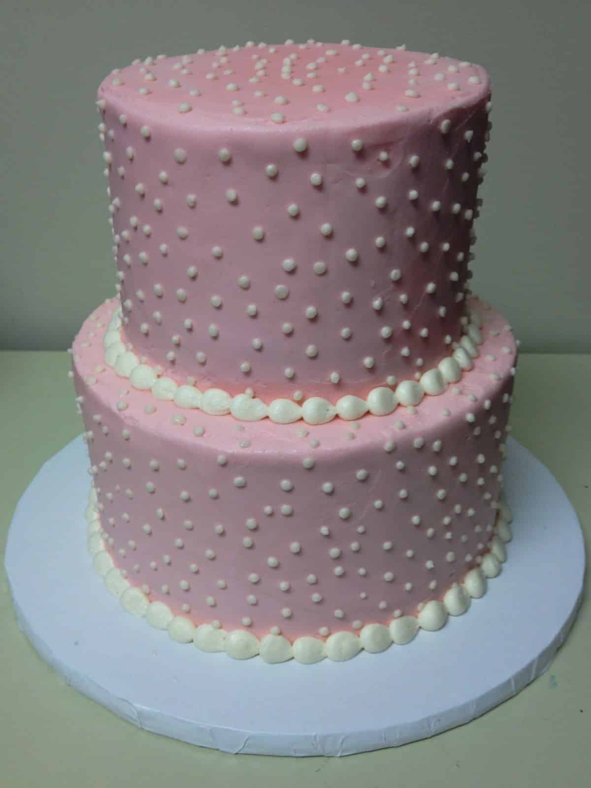 A pink minimalist cake with white dots.