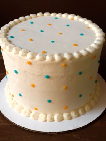 A simple white cake with a dainty minimalist dot pattern.